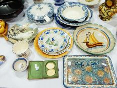 A pair of Quimper plates decorated with figures and floral borders,