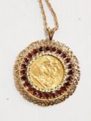 A full sovereign in a pierced 9ct gold mount set with garnets and on a rope-twist chain, 18.