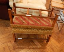 Two gold floral decorated footstools on square legs and united by stretchers