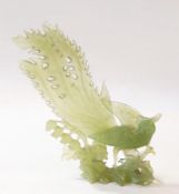 20th century carved jade model of a pheasant/peacock standing on rocky outcrop among foliage,
