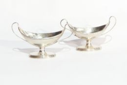 A pair of George III silver boat-shaped salts with reeded borders, twin handles,