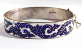 A sterling silver and enamel bangle with foliate scroll blue and white enamelling