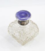 A silver-mounted glass dressing table bottle with enamelled cover,