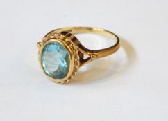 A 9ct gold ring set with an oval mixed cut aquamarine within a ropetwist border