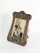 A George V silver photograph frame with overall scrollwork engraving with an easel support,