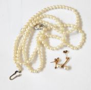 A string of uniform cultured beads with a silver clasp set with a single pearl,