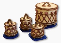 Four pottery cake boxes by Rachel Kneebone, the larger box cylindrical, the lid with arched handle,