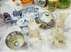 A bisque model of a poodle sitting on a cushion,