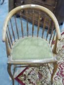 A beech framed turned spindle back tub chair on cabriole shaped supports with turned stretchers and