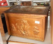 A beaten brass clad slipper box containing assorted brass ornaments, jugs, horns, etc.
