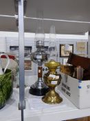 A chrome and treen oil lamp on ceramic base and another brass oil lamp