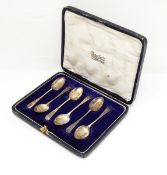 A set of six silver coffee spoons with engraved decoration, in fitted case and a silver thimble.