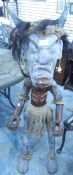 A 20th century tribal figure with horns, hessian skirt and anklets,