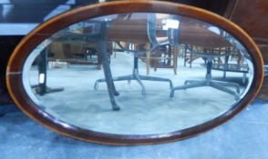 An Edwardian oval bevelled plate wall mirror within a mahogany and satinwood banded frame,