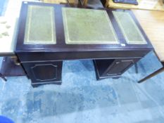 A mahogany finish kneehole pedestal desk, the top inset three tooled leather panels,