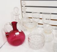 A cranberry glass ewer, cut glass goblet with etched vine decoration, decanters,