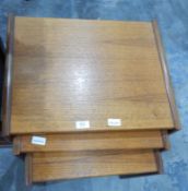 A nest of three teak finish tables