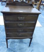 An Edwardian four tray music cabinet with raised shaped backboard