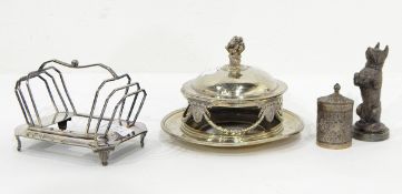 A silver plated mascot in the form of a begging dog, a canister with repousse decoration,