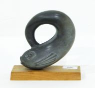 A stylised model of a dolphin set upon a wooden plinth