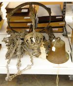 A metal hanging large bell and a pierced ornate metal hanging light fitting