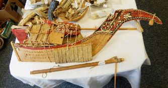 A painted wooden model boat with woven papyrus sails,