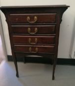 Edwardian stained wood four-drawer music chest with swan neck handles, on tapering supports,