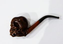 A carved wooden pipe, the bowl in the form of skull supported on lady's hand, the case marked 