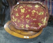 A red lacquer tray by Jennens & Betteridge with gold floral and butterfly patterns and a modern