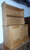 A pine dwarf display cabinet with open shelf, cupboard to base, on block plinth,