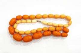 A single row of graduated orange bakelite beads