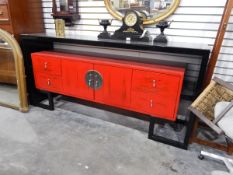 A Chinese lacquer sideboard with red mid section,