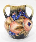 A two-handled vase with tube lined decoration, of pomegranates and berries, in the Moorcroft style,