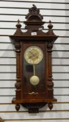 A stained walnut Vienna regulator style wall clock having ornate, foliate and floral pediment,