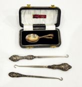 Three button hooks with silver handles, a pair of Victorian silver plated serving spoons,