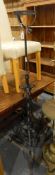A wrought iron lamp stand on openwork tripod scroll base