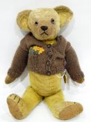 A vintage mohair teddy with glass eyes with a 1902 coronation medal pinned to him
