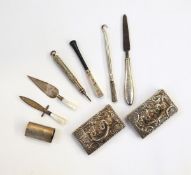 Pair of silver place name holders, the rectangular bases with embossed floral decoration, 7cm long,