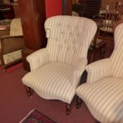 A pair of French armchairs upholstered in buttoned striped linen fabric raised on turned supports