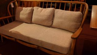 A retro Ercol three seater sofa with sitckback and cushion seats upholstered in grey fabric.