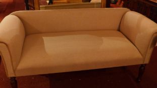 A contemporary designer two seater settee upholstered in beige linen fabric on turned supports.