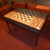 A 20th century mosaic and chess board topped low table on cast iron supports.