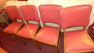 A set of four beech dining chairs with faux leather upholstery.