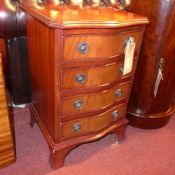 A mahogany bedside chest of serpentine outline and fitted four drawers on bracket feet.