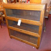 A retro oak three tier stacking bookcase with glazed panel doors