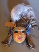 A Venetian wall mask with feather plumes.