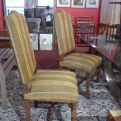 A set of four high backed dining chairs with green and yellow striped upholstery raised on turned