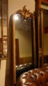 A French pier mirror, the shaped bevelled plate within ornate gilt frame with scrolling surmount.
