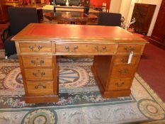 A 19th century oak pedestal desk the leather lined top above nine drawers with brass handles.