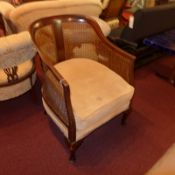A mahogany Bergere chair with carved back and velour upholstered cushion seat.